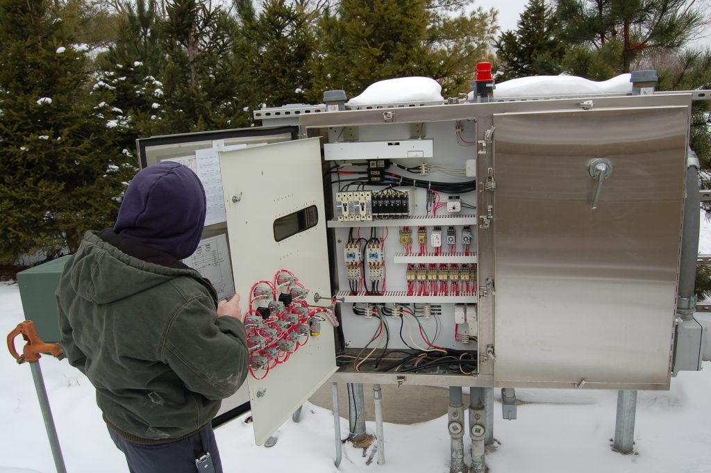 Plant personnel inspecting lift station Control panel