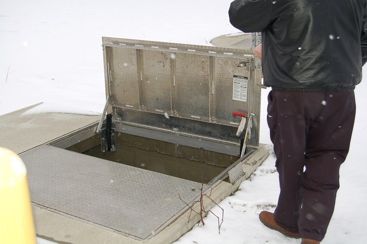 Plant personnel looking into the wet well at a lift station